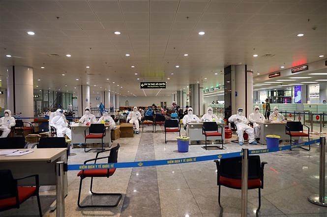 [Foto] Terminal internacional de Noi Bai refuerza control medico de pasajeros en su llegada al pais hinh anh 1