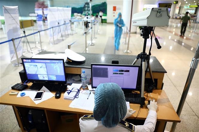 [Foto] Terminal internacional de Noi Bai refuerza control medico de pasajeros en su llegada al pais hinh anh 5